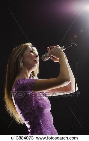 Woman singing in spotlight View Large Photo Image Stock Image - Woman singing in spotlight. Fotosearch