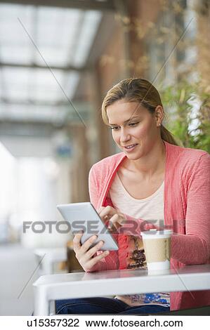 Woman using tablet in cafe View Large Photo Image Stock Image - Woman using tablet in cafe. Fotosearch