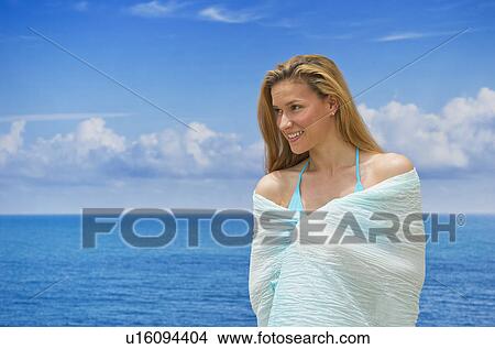 Woman wrapped in towel by sea View Large Photo Image Picture - Woman wrapped in towel by sea. Fotosearch