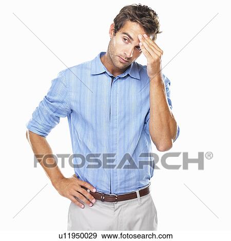 Young business man standing with hand on forehead and looking away View Large Photo Image Stock Photo - Young business man standing with hand on forehead and looking away. Fotosearch