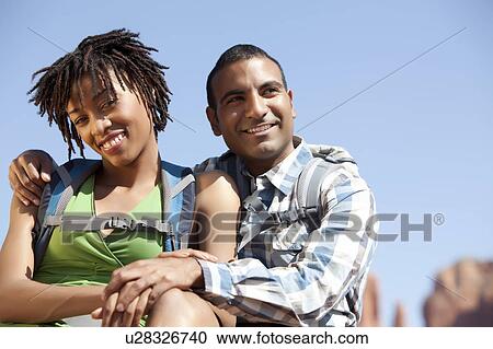 Stock Image - Young couple hiking and enjoying desert scenery. Fotosearch