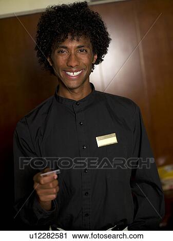 Young male receptionist giving card View Large Photo Image Stock Image - Young male receptionist giving card. Fotosearch