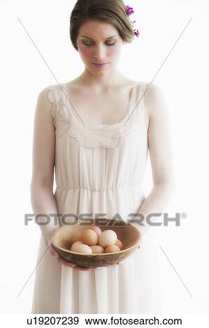 Young woman carrying basket of eggs View Large Photo Image Stock Photo - Young woman carrying basket of eggs. Fotosearch