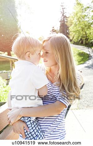 Stock Photo - Young woman embracing son (2-3) in park. Fotosearch