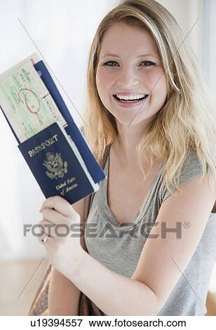 Young woman holding passports and plane tickets View Large Photo Image Stock Photo - Young woman holding passports and plane tickets. Fotosearch