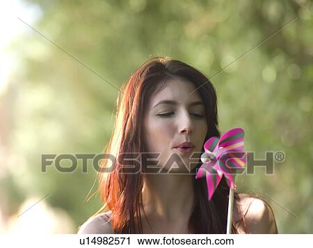 Stock Image - Young woman holding pinwheel. Fotosearch