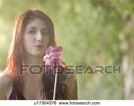 Stock Photograph - Young woman holding pinwheel. Fotosearch