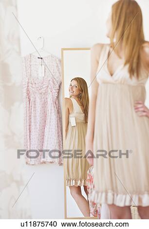 Young woman in clothes shop fitting dress View Large Photo Image Stock Image - Young woman in clothes shop fitting dress. Fotosearch