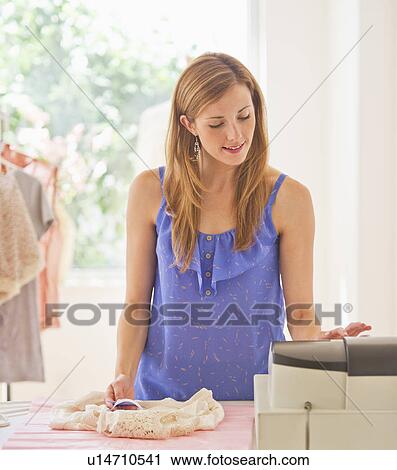 Young woman in clothes shop View Large Photo Image Stock Image - Young woman in clothes shop. Fotosearch