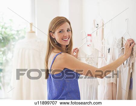 Young woman in clothes shop View Large Photo Image Stock Photo - Young woman in clothes shop. Fotosearch