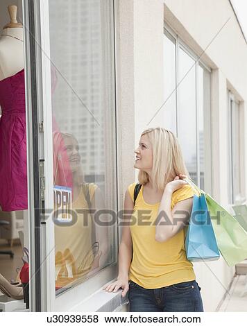 Young woman in front of boutique View Large Photo Image Stock Photo - Young woman in front of boutique. Fotosearch