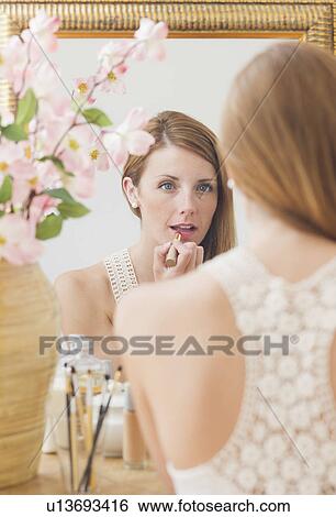 Stock Photograph - Young woman in front of mirror. Fotosearch