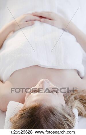 Young woman lying wrapped in towel View Large Photo Image Stock Photo - Young woman lying wrapped in towel. Fotosearch