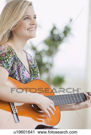 Young woman playing guitar View Large Photo Image Stock Image - Young woman playing guitar. Fotosearch