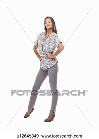 Young woman standing with hands on hips and smiling against white background View Large Photo Image Stock Photo - Young woman standing with hands on hips and smiling against white background. Fotosearch