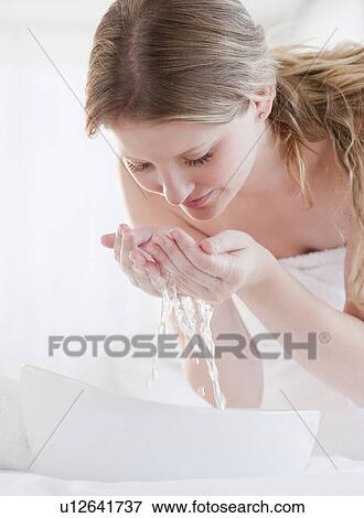 Young woman washing face View Large Photo Image Stock Photo - Young woman washing face. Fotosearch