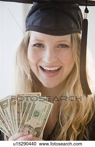 Young woman wearing graduation gown holding banknotes View Large Photo Image Stock Image - Young woman wearing graduation gown holding banknotes. Fotosearch