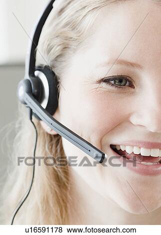 Stock Photo - Young woman wearing headset. Fotosearch