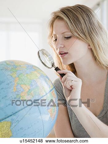 Young woman with magnifying glass searching on globe View Large Photo Image Stock Photo - Young woman with magnifying glass searching on globe. Fotosearch
