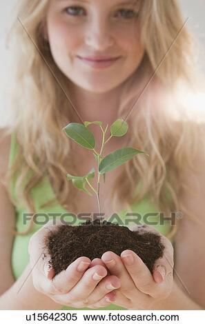 Stock Photography - Young woman with seedling. Fotosearch