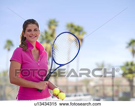 Stock Photography - Young woman with tennis balls and racket. Fotosearch