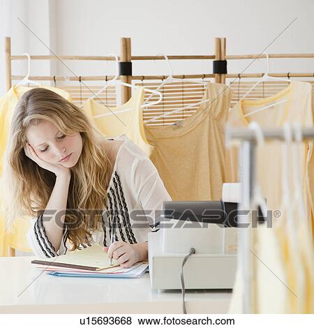 Young woman working in clothes shop View Large Photo Image Stock Photo - Young woman working in clothes shop. Fotosearch