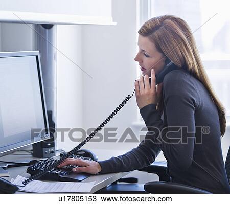 Young woman working in office View Large Photo Image Stock Image - Young woman working in office. Fotosearch