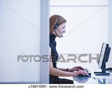 Stock Image - Young woman working in office. Fotosearch