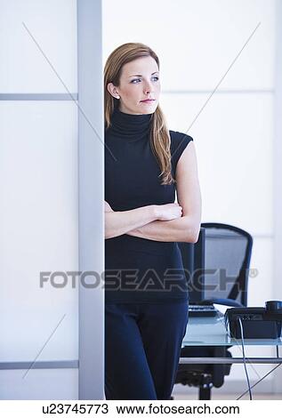 Stock Image - Young woman working in office. Fotosearch