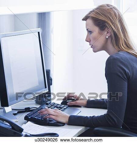 Young woman working in office View Large Photo Image Stock Photograph - Young woman working in office. Fotosearch