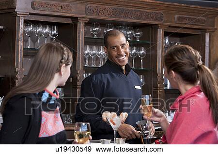 Stock Photo - Young women enjoying apres ski drink in bar. Fotosearch