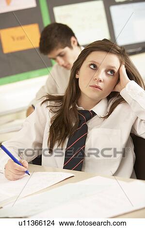 Picture - Bored Female Teenage Student Studying In Classroom. Fotosearch