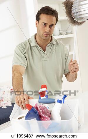 Stock Photo - Bored Man Cleaning Light Fitting With Feather Duster. Fotosearch