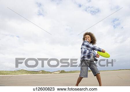 Boy playing frisbee on beach View Large Photo Image Stock Image - Boy playing frisbee on beach. Fotosearch