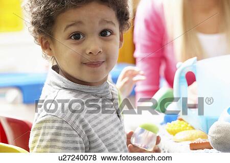 Stock Photo - Boy playing with toys in nursery. Fotosearch