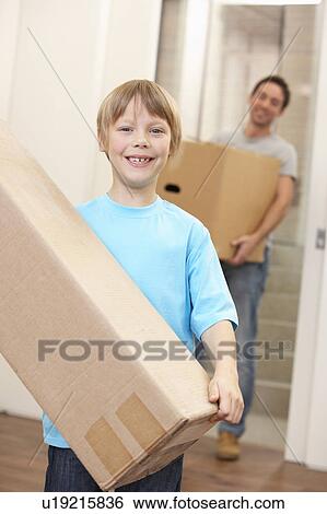Stock Photograph - Boy with young man on moving day carrying cardboard box. Fotosearch