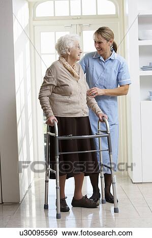 Carer Helping Elderly Senior Woman Using Walking Frame View Large Photo Image Stock Photo - Carer Helping Elderly Senior Woman Using Walking Frame. Fotosearch