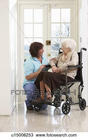 Stock Image - Carer With Disabled Senior Woman Sitting In Wheelchair. Fotosearch