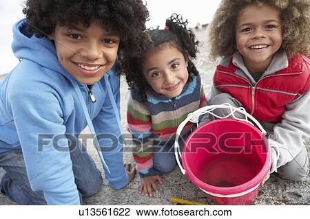 Stock Image - Children fishing for crabs. Fotosearch