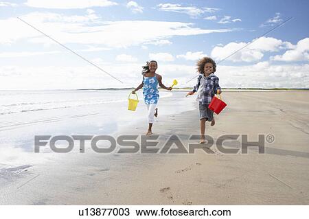 Stock Image - Children playing on beach. Fotosearch