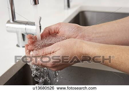 Stock Photograph - Close Up Of Woman Washing Hands At Kitchen Sink. Fotosearch