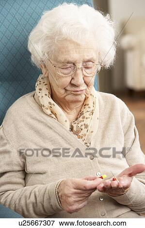 Stock Photo - Confused Senior Woman Looking At Medication. Fotosearch