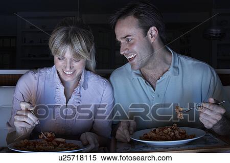 Stock Photography - Couple Enjoying Meal Whilst Watching TV. Fotosearch