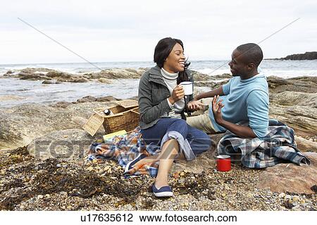 Couple having picnic on beach View Large Photo Image Stock Image - Couple having picnic on beach. Fotosearch