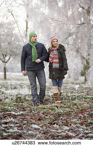 Stock Image - Couple On Winter Walk Through Frosty Landscape. Fotosearch