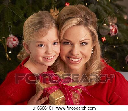 Stock Image - Daughter Giving Mother Christmas Gift. Fotosearch