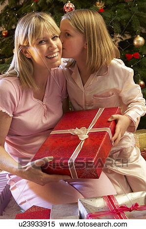 Daughter Giving Mother Christmas Present In Front Of Tree View Large Photo Image Stock Photography - Daughter Giving Mother Christmas Present In Front Of Tree. Fotosearch
