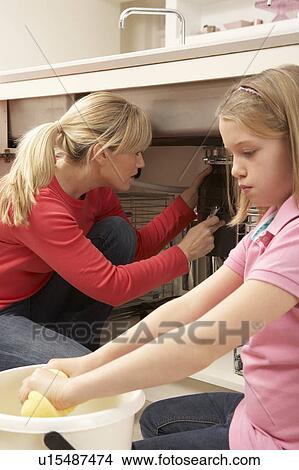 Picture - Daughter Helping Mother To Mop Up Leaking Sink. Fotosearch