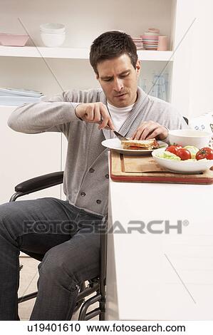 Stock Image - Disabled Man Making Sandwich In Kitchen. Fotosearch