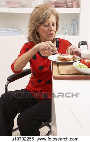 Stock Photography - Disabled Senior Woman Making Sandwich In Kitchen. Fotosearch